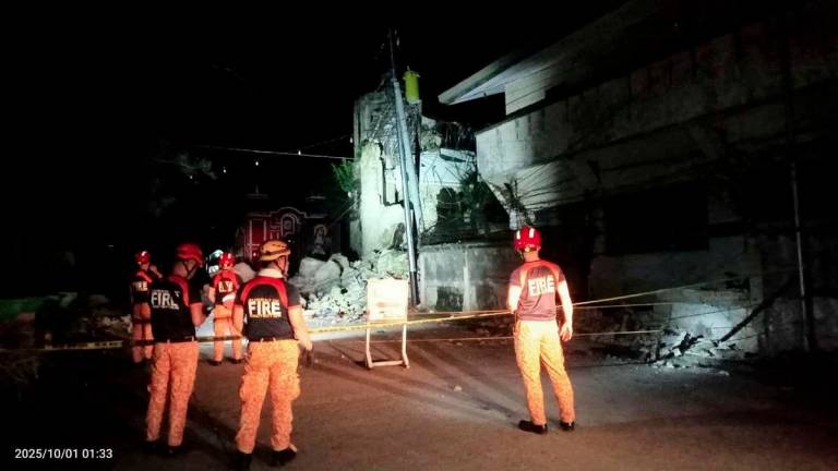 Rescue personnel stand in front of a damaged structure following a 6.9-magnitude earthquake, in Daanbantayan, Cebu Province, Philippines, October 1, 2025. - Municipality of Daanbantayan/Handout via REUTERSPIX