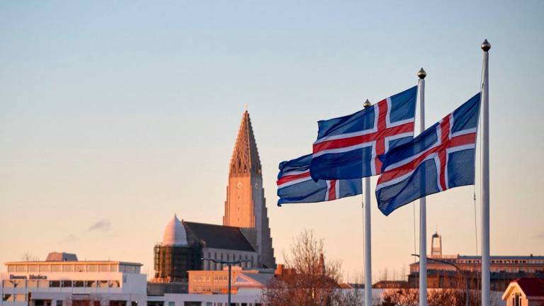 Icelandic national flags are seen flying outside a polling station, as the Hallgrimskirkja church is seen in the background, in Reykjavik, Iceland, on Nov 30,