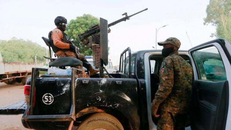 A soldier sits on one of the trucks used to bring back the girls who were kidnapped from a boarding school in the northwest Nigerian state of Zamfara, following their release in Zamfara, Nigeria. Photo: Reuters