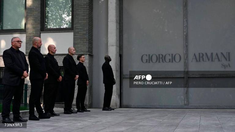 Armani's security staff members lined up outside the Armani Theatre where late Italian fashion designer Giorgio Armani lies-in state, in Milan on September 7, 2025. - AFP