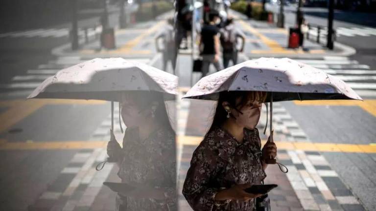 Some Tokyo residents carry parasols to beat the heat © Philip FONG / AFP