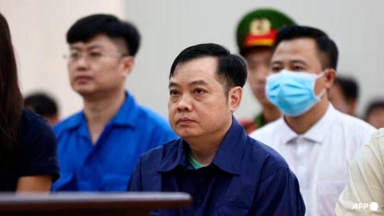 An Phu karaoke bar owner Le Anh Xuan (C) sitting with defendants on trial over a deadly 2022 karaoke bar fire at a court in Vietnam’s southern Binh Duong province - AFPpix