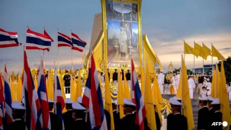 A portrait of Thailand’s King Maha Vajiralongkorn stands among royal and Thai flags outside the Grand Palace during celebrations to mark the King’s 70th birthday in Bangkok - AFPpix