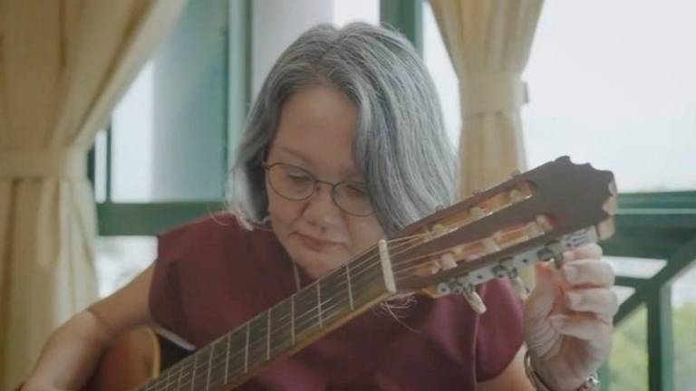 Sylvia Lim, the chair of the Workers’ Party in Singapore, tunes a guitar as she introduces herself as the Candidate of the 2025 General Election, at an unknown location, in this screen grab taken from a handout video released on April 26, 2025. AFPpix