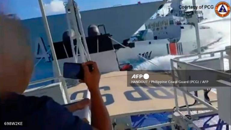This handout video grab released and taken on August 11, 2025 by the Philippine Coast Guard shows an incident between a Chinese Navy vessel (L) and a Chinese Coast Guard ship (R) as seen from a Philippine fisheries boat near Scarborough Shoal in the disputed South China Sea. (Photo by Handout / Philippine Coast Guard (PCG) / AFP)