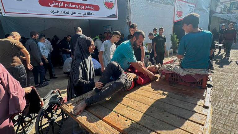 Palestinian assist casualties following an Israeli strike, amid the Israel-Hamas conflict, in Beit Lahiya in the northern Gaza Strip - REUTERSpix