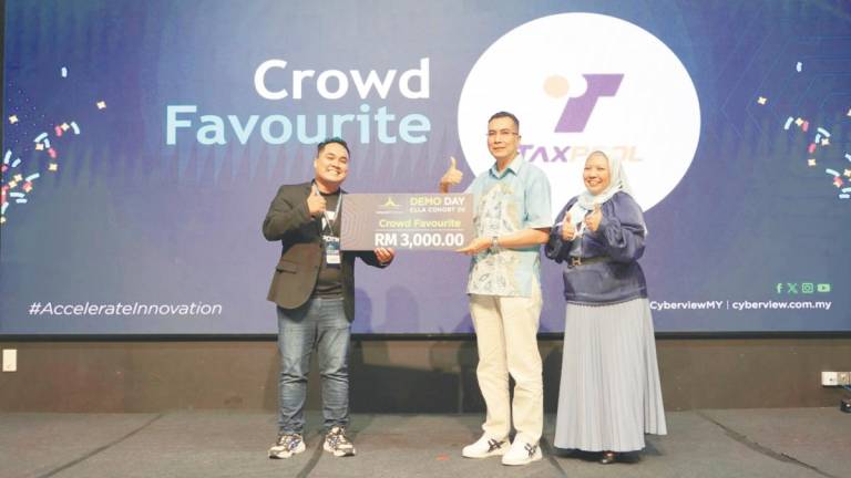 Syamil (left) receiving the Crowd Favourite Award from Cyberview Sdn Bhd CEO Kamarul Ariffin Abdul Samad. On the right is Cyberview technology hub development division head Shafinaz Salim.