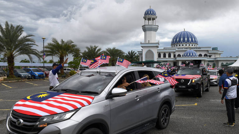 Participants of the Penang Kembara Merdeka Jalur Gemilang (KMJG) convoy continue their journey after receiving the Jalur Gemilang from the Perak participants at the compound of Sungai Acheh Mosque here today. – BERNAMA