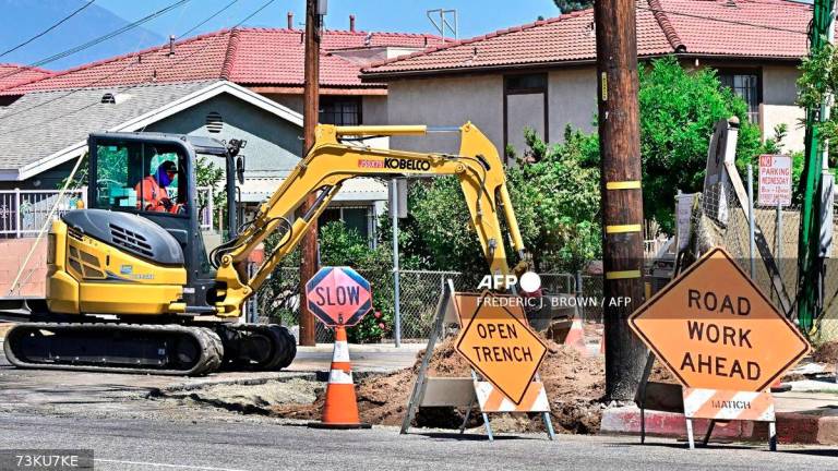 A construction worker operates an excavator at a work site in San Gabriel, California on September 5, 2025. - AFP
