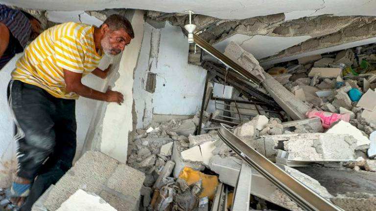 A Palestinian man walks through the rubble of a house where Hamas leader Ismail Haniyeh's sister and other relatives were killed in an Israeli strike, amid Israel-Hamas conflict, at the Shati (Beach) refugee camp, in Gaza City - REUTERSpix