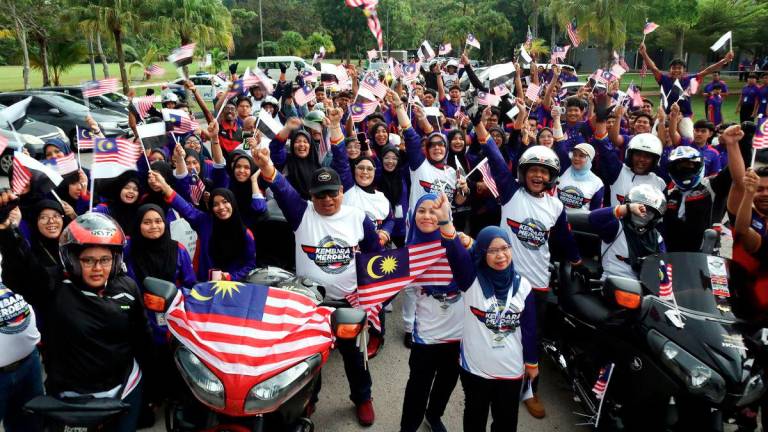 Pahang Information Department Director Rohani Chik (front) with participants and students chanting “Merdeka” three times before the flag-off of the state-level Kembara Merdeka Jalur Gemilang at Paya Besar Community College on August 12. – BERNAMA