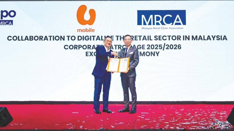 Tan (left) and Phua at the formalisation of the collaboration between U Mobile and the Malaysia Retail Chain Association.