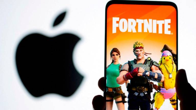 Fortnite game graphic is displayed on a smartphone in front of Apple logo in this illustration created on May 2, 2021. REUTERSpix