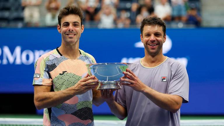 Spain’s Marcel Granollers (L) and Argentina’s Horacio Zeballos pose with the trophy after winning the men’s doubles championship title. - TIMOTHY A. CLARY / AFP