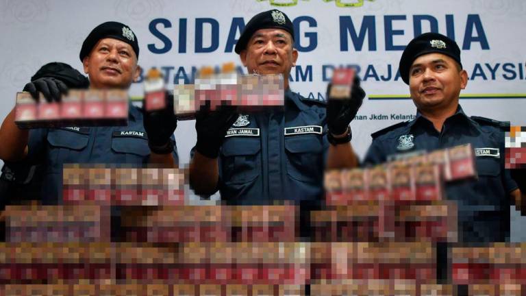 Pengarah Jabatan Kastam Diraja Malaysia (JKDM) Kelantan Wan Jamal Abdul Salam Wan Long (tengah) bersama para pegawai menunjukkan sebahagian rokok putih yang dirampas pada sidang media di Wisma Kastam Padang Bongor hari ini - foto BERNAMA