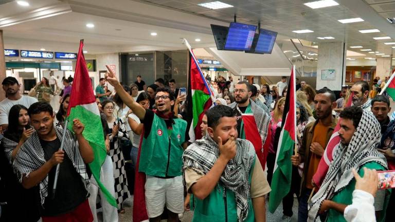 Supporters hold flags and wear keffiyehs as they welcome activists from the Global Sumud flotilla, which was intercepted while aiming to reach Gaza and break Israel’s naval blockade, at the Tunis-Carthage Airport, in Tunis, Tunisia, October 5, 2025. REUTERS/Jihed Abidellaoui