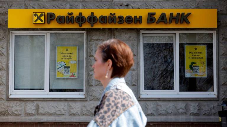 FILE PHOTO: A pedestrian walks past a branch of Raiffeisen Bank in Moscow, Russia, April 18, 2025. REUTERS/Maxim Shemetov/File Photo