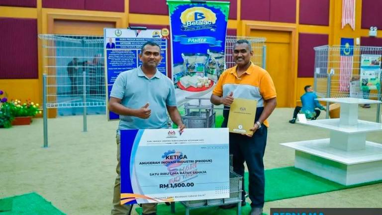 R. Ratha Krishnan, 43, (right) decided to take early retirement from the Department of Veterinary Services (DVS) five years ago and founded Betalac Dairy House Sdn Bhd, a dairy processing company based in Jelapang, Ipoh. - Photo by BERNAMA