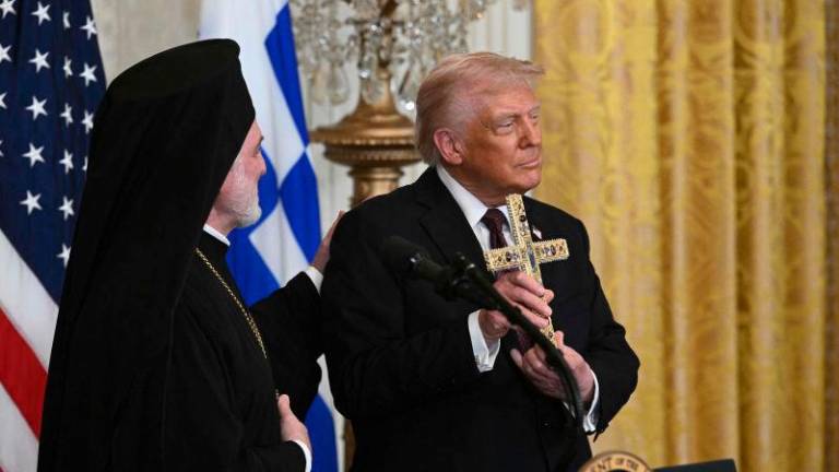 Trump displays a cross given to him by Elpidophoros of America (L), a bishop of the Ecumenical Patriarchate of Constantinople, during a Greek Independence Day celebration in the East Room of the White House in Washington, DC, AFPpix