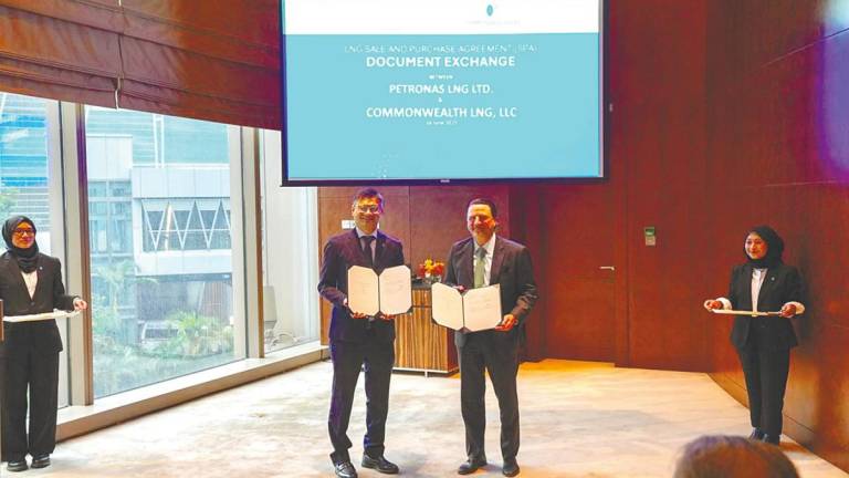 Ezran (left) and Farhad exchanging documents after the agreement signing ceremony on the sidelines of Energy Asia 2025.