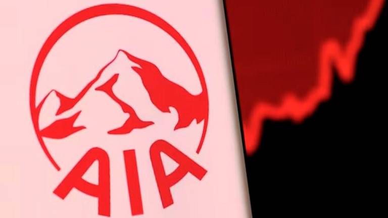 AIA Group logo is pictured on a smartphone in front of an electronic display showing stock graph in this illustration taken, December 4, 2021. - REUTERS