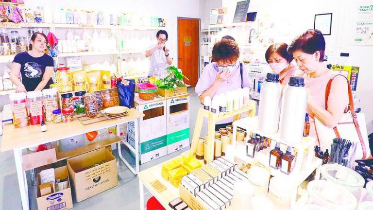 Lee (left) and Tan serving customers at Minimize Zero Waste Store – Amirul Syafiq/theSun