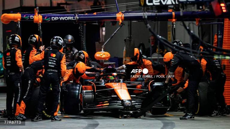 McLaren's Australian driver Oscar Piastri makes a pit stop during during the Formula One Singapore Grand Prix night race at the Marina Bay Street Circuit in Singapore on October 5, 2025. - POOL via AFP