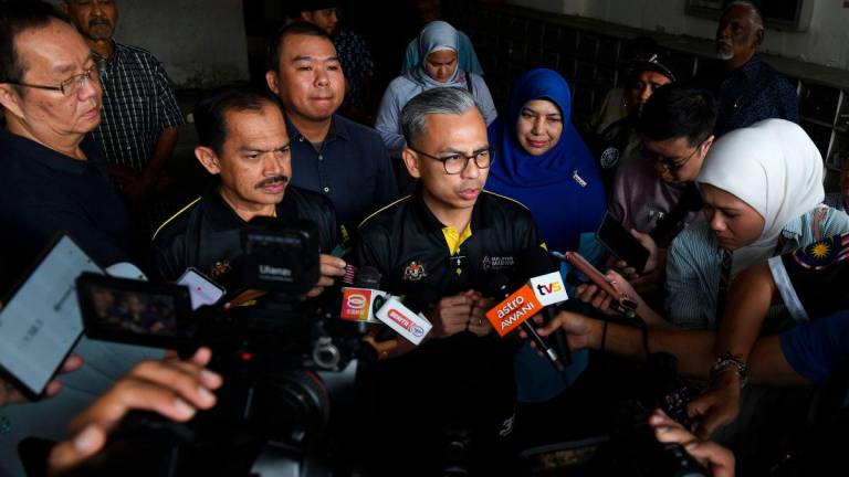 Menteri Komunikasi Datuk Fahmi Fadzil menjawab pertanyaan media selepas menyampaikan bantuan Tabung Kasih@HAWANA kepada wartawan Kwong Wah Yit Poh, Choo Kar Chun, 44, di kediaman wartawan berkenaan di Air Itam hari ini - BERNAMA