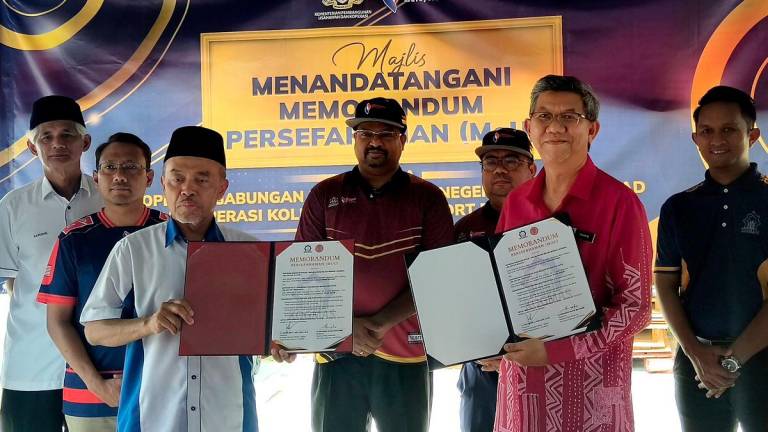 Pengerusi Jawatankuasa Bertindak Keusahawanan, Sumber Manusia, Perubahan Iklim, Koperasi dan Kepenggunaan Negeri Sembilan S Veerapan (belakang, tengah) menyaksikan pertukaran dokumen memorandum persefahaman di antara Koperasi Gabungan Masjid-Masjid Negeri Melaka Berhad (Kogmas) yang diwakili Pengerusinya Zaidan Abd Hadi (depan, kiri) dan Koperasi Kolej Vokasional (KV) Port Dickson Berhad yang diwakili Pengarah Kolej Mohammad Shafie Hamir (depan, kanan) di sini hari ini.- fotoBERNAMA