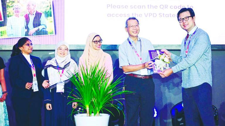 Public health milestone... Kejal (left) looks on as MSGM president Dr Alan Ch’ng (right) receives a copy of the booklet from Prof Dr Philip Poi Jun Hua, a veteran professor of geriatrics in Malaysia and a pioneer of MSGM. With them are Assoc Prof Dr Hakimah Sallehuddin (2nd left) and Dr Wan Mazlina Wan Mustapa.