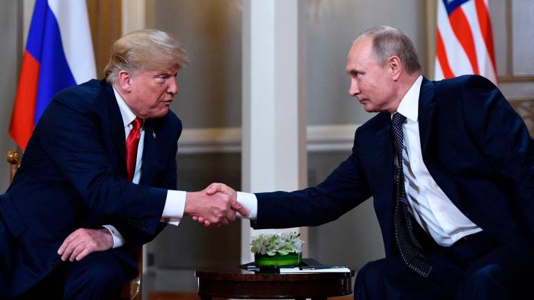 (FILES) Russian President Vladimir Putin (R) and US President Donald Trump shake hands before a meeting in Helsinki on July 16, 2018. - Brendan Smialowski / AFP