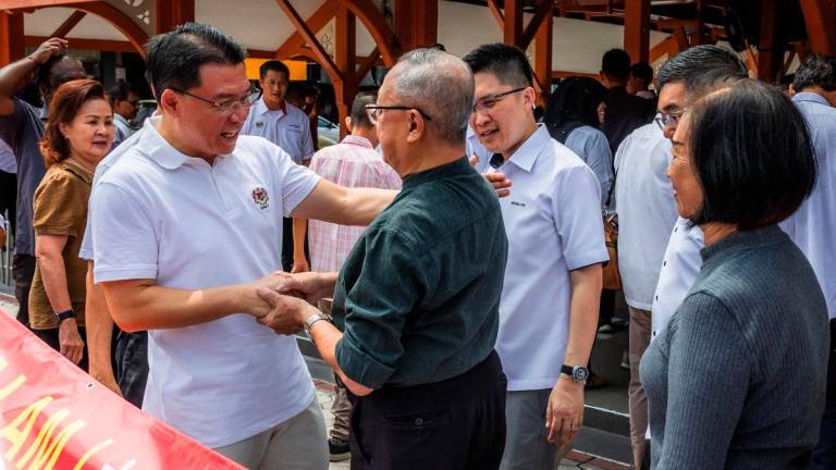 Menteri Perumahan dan Kerajaan Tempatan Nga Kor Ming (kiri) beramah mesra bersama para peniaga ketika hadir ke program Sentuhan Kasih KPKT 3.0 di tapak Pasar Besar Siang dan Malam Bandar Taiping hari ini - BERNAMA