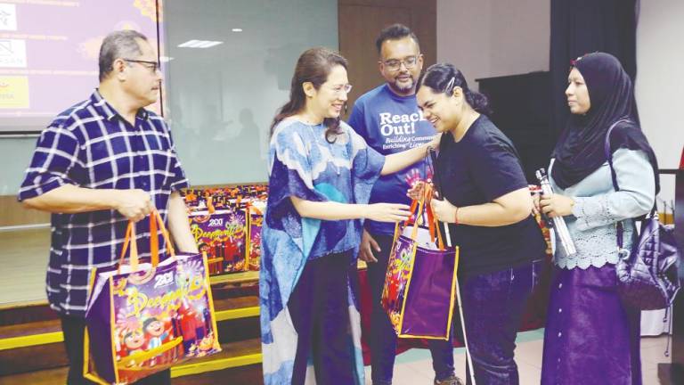 Sunita handing out gift bags to visually impaired beneficiaries at the Malaysian Association for the Blind multipurpose hall in Brickfields, Kuala Lumpur yesterday. – AMIRUL SYAFIQ/THESUN