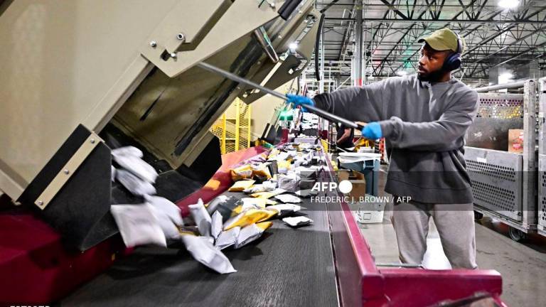 (FILES) Postal workers sort through mail and packages during a media tour hosted by the US Postal Service at the Los Angeles Processing and Distribution Center, the largest in the country, equivalent to 29 football fields, on Nov 30, 2023. Photo by Frederic J. BROWN / AFP