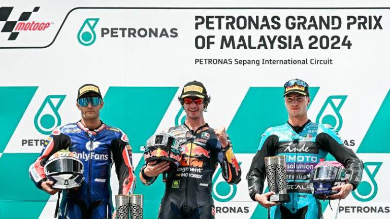 Red Bull KTM Ajo’s Italian rider Celestino Vietti (C), OnlyFans American Racing Team’s Jorge Navarro (L) and CFMOTO Aspar Team’s Spanish rider Izan Guevara (R) pose on the podium after the Moto2 race of the MotoGP Malaysian Grand Prix at the Sepang International Circuit in Sepang - AFP