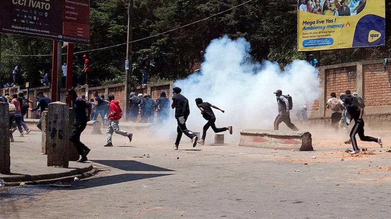 Protesters run as Malagasy riot police use tear gas during a demonstration against frequent power outages and water shortages, near the University of Antananarivo, Madagascar September 29, 2025. - REUTERSPIX