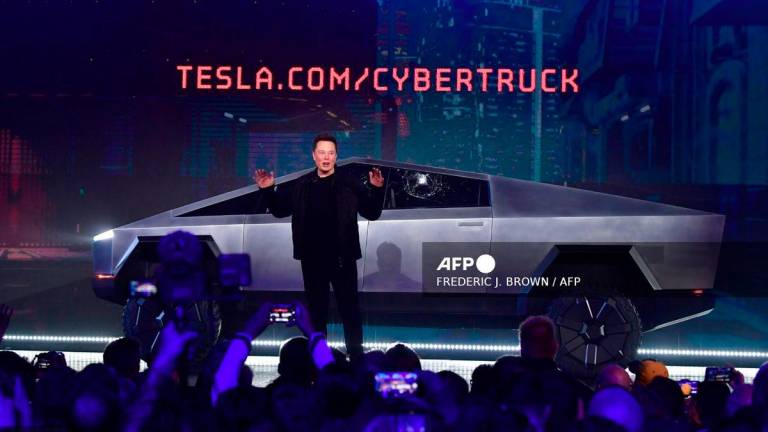 Tesla co-founder and CEO Elon Musk speaks in front of the newly unveiled all-electric battery-powered Tesla's Cybertruck with shattered windows, after a failed resistance test, at Tesla Design Center in Hawthorne, California, on November 21, 2019. - AFP