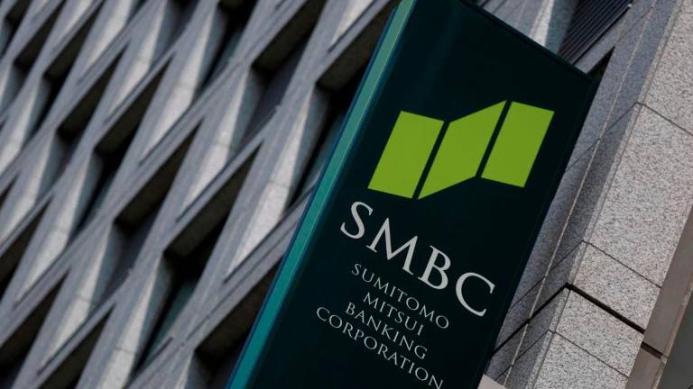 A sign board of Sumitomo Mitsui Banking Corporation is seen outside its branch in Tokyo July 30, 2014. - REUTERS