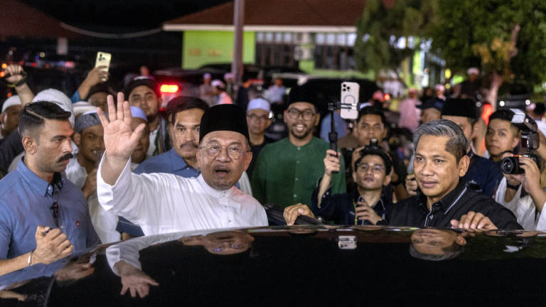 Prime Minister Datuk Seri Anwar Ibrahim waves to the crowd as he departs from the Mahabah MADANI Umara dan Ulama Programme at the Kelantan Islamic Foundation (YIK) Pondok Learning Centre yesterday. – BERNAMA
