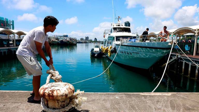 Fishermen secure their boats at Wushih Harbor in Yilan as Typhoon Podul approaches on August 12, 2025. - I-Hwa Cheng / AFP