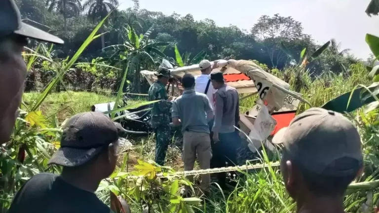 Security personnel inspect the wreckage of a hang glider that crashed into a public cemetery in Ciampea District, Bogor, West Java, on Sunday, Aug. 3, 2025. (Credit: B-Universe piv via Jakarta Globe)