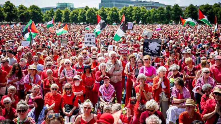 Protestors wave Palestinian flags and signs as they attend a demonstration called by Oxfam Novib, PAX, Amnesty International, Save the Children and Doctors Without Borders in support for the Palestinians, in The Hague on June 15, 2025. (Photo by ANP KOEN VAN WEEL / ANP / AFP)