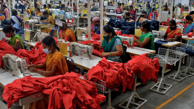 Garment workers stitch shirts at a textile factory of Texport Industries in Hindupur town in the southern state of Andhra Pradesh, India, February 9, 2022. - REUTERS
