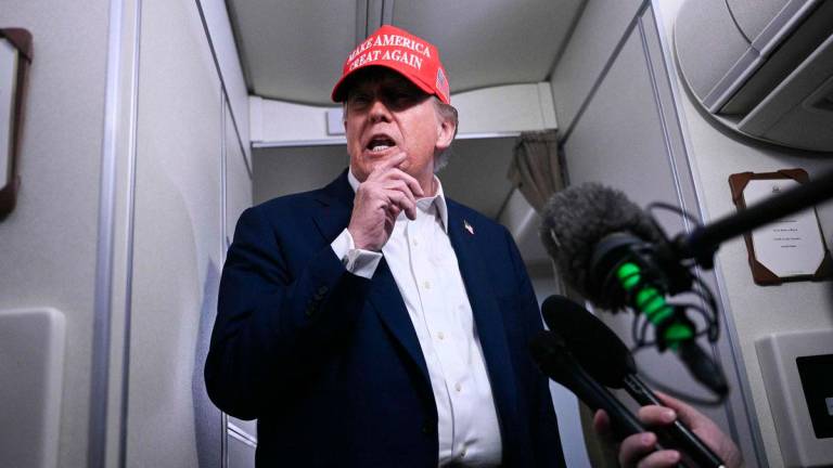 US President Donald Trump speaks to journalists aboard Air Force One after departing Joint Base Andrews, Maryland on his way to Bedminster - Brendan SMIALOWSKI / AFPPix