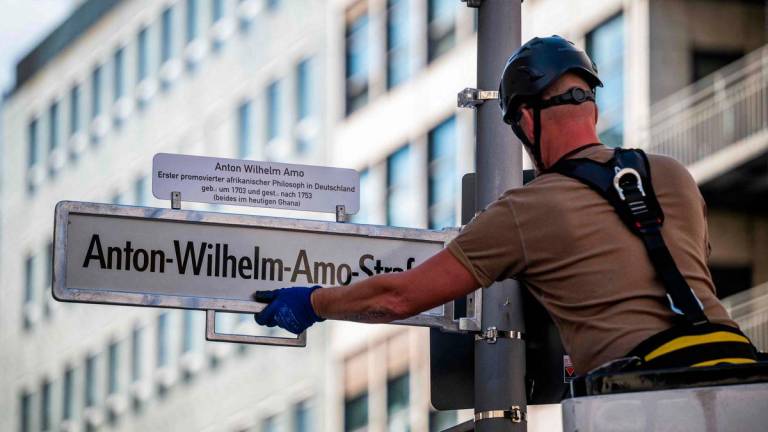 A worker installs a street sign bearing what is supposed to become the new name for the ‘Mohrenstrasse’ (Moor street), the ‘Anton-Wilhelm-Amo-strasse’ in Berlin’s Mitte district on August 22, 2025. The street should have been renamed on August 23, 2025 as ‘Anton-Wilhelm-Amo-Straße’ to honor Anton Wilhelm Amo, a philosopher of African descent who became the first black scholar to receive a doctorate from a German university. (Photo by John MACDOUGALL / AFP)