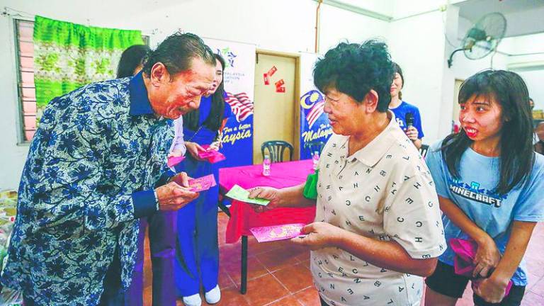 Tan presenting ang pow to PRR residents at the event. – Adam Amir Hamzah/THESUN