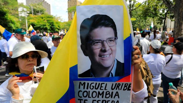 A woman holds a national flag during the so-called “Silent March” to show support for the health of Senator Miguel Uribe Turbay and to call for peace for the country in Medellin, Colombia, on June 15, 2025. Uribe, a 39-year-old conservative senator, was shot twice in the head and once in the leg while giving a speech in a park on June 7 in western Bogota. - JAIME SALDARRIAGA / AFP
