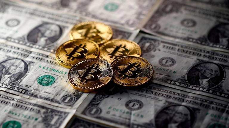 FILE PHOTO: Bitcoin (virtual currency) coins placed on Dollar banknotes are seen in this illustration picture, November 6, 2017. REUTERS