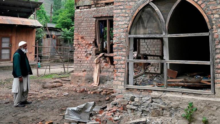 A local resident inspects his house that - AFPPIX