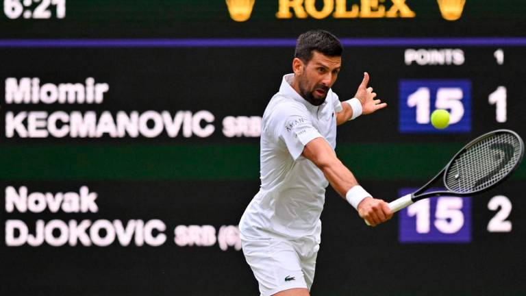 Serbia’s Novak Djokovic plays a backhand return to Serbia’s Miomir Kecmanovic during their men’s singles third round tennis match on the sixth day of the 2025 Wimbledon Championships at The All England Lawn Tennis and Croquet Club in Wimbledon, southwest London, on July 5, 2025 - Photo by Glyn KIRK / AFP